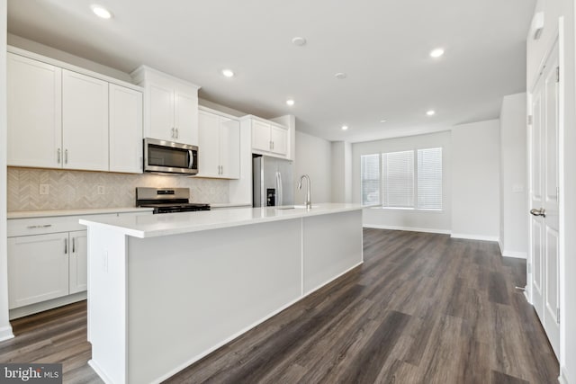 kitchen with white cabinets, a kitchen island with sink, and appliances with stainless steel finishes