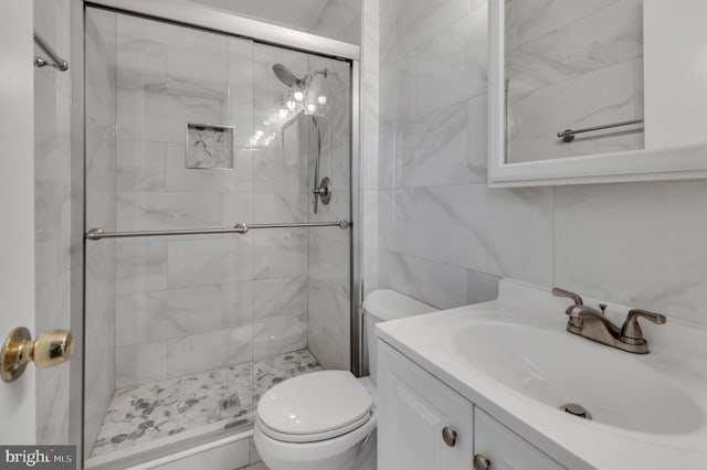 bathroom featuring vanity, toilet, an enclosed shower, and tile walls