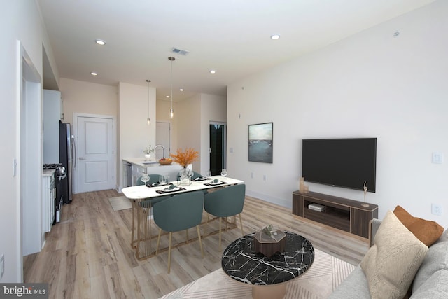 living room featuring sink and light wood-type flooring