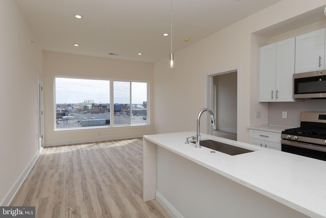 kitchen featuring white cabinets, sink, tasteful backsplash, decorative light fixtures, and stainless steel appliances