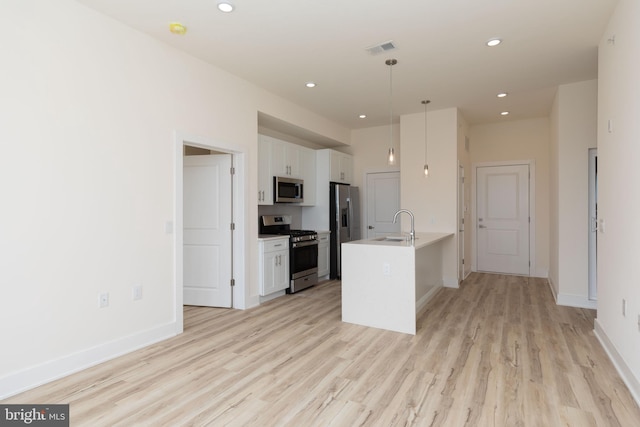 kitchen featuring white cabinetry, sink, hanging light fixtures, and appliances with stainless steel finishes