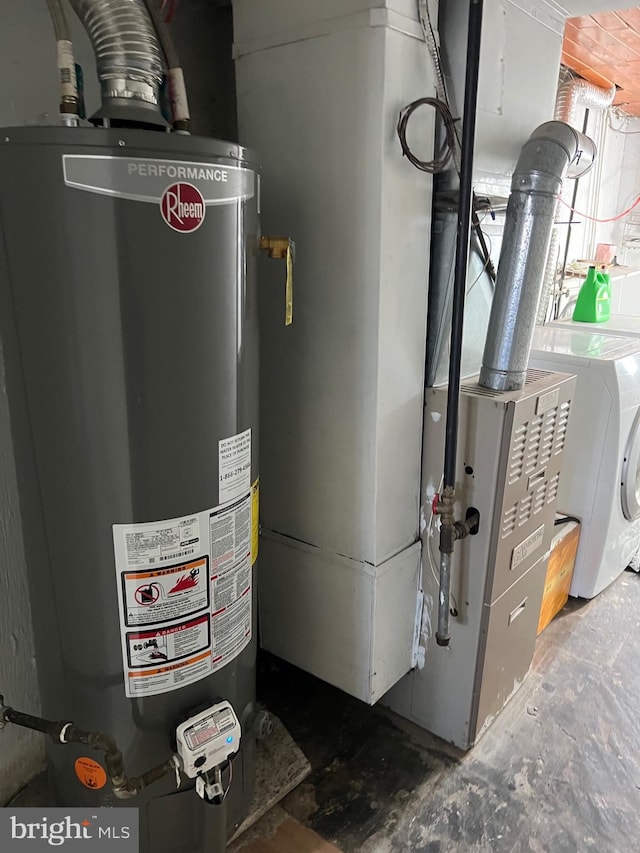 utility room with gas water heater and washer / dryer