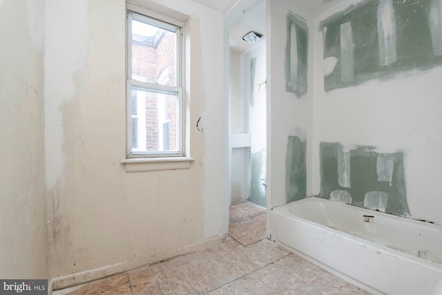 bathroom featuring a tub and a wealth of natural light