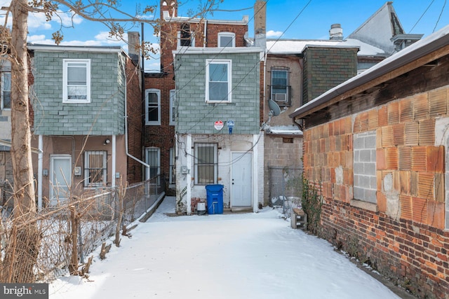 view of snow covered back of property