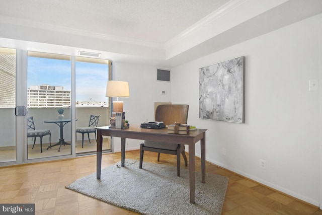 office space with ornamental molding, parquet floors, a textured ceiling, and a tray ceiling