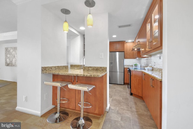 kitchen featuring decorative light fixtures, tasteful backsplash, kitchen peninsula, stainless steel appliances, and light stone countertops