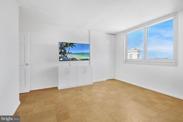 unfurnished room featuring a textured ceiling