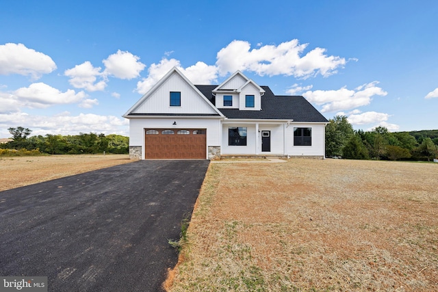 modern farmhouse style home featuring a garage, a front lawn, and covered porch