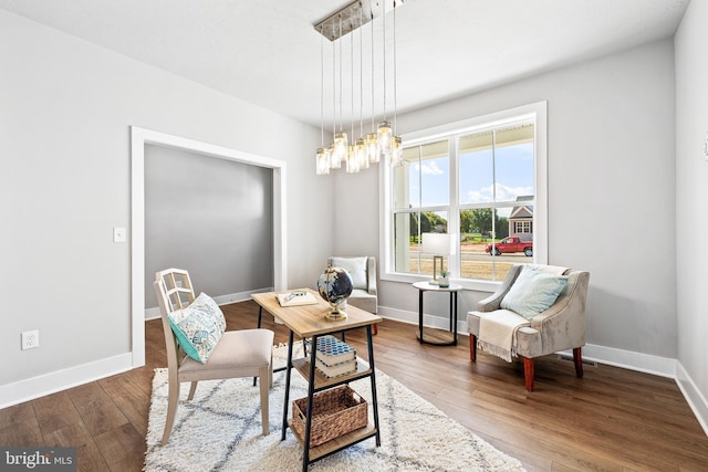 living area with dark hardwood / wood-style flooring and a notable chandelier