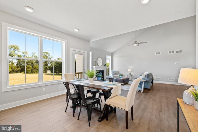 dining room with vaulted ceiling, ceiling fan, and light wood-type flooring