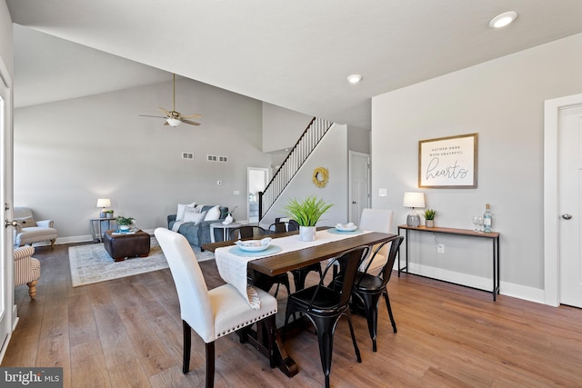 dining area with wood-type flooring, high vaulted ceiling, and ceiling fan