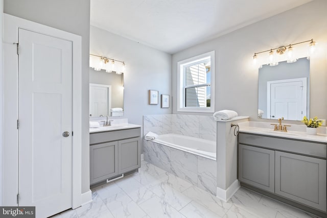 bathroom with vanity and tiled tub