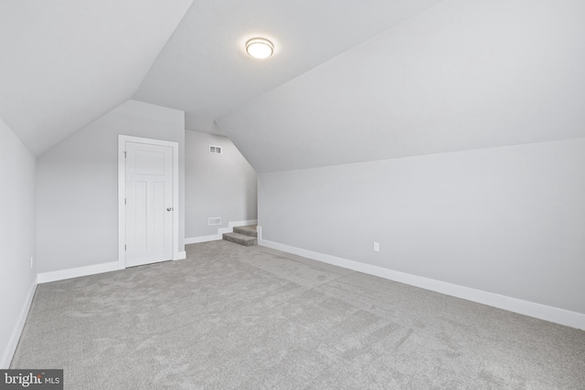 additional living space with lofted ceiling and light carpet