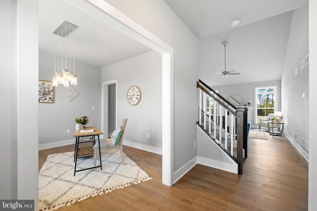 interior space featuring wood-type flooring and ceiling fan with notable chandelier