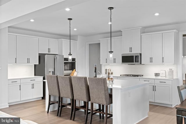 kitchen with white cabinetry, pendant lighting, and appliances with stainless steel finishes