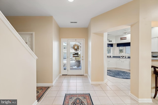 tiled foyer with ceiling fan and a healthy amount of sunlight