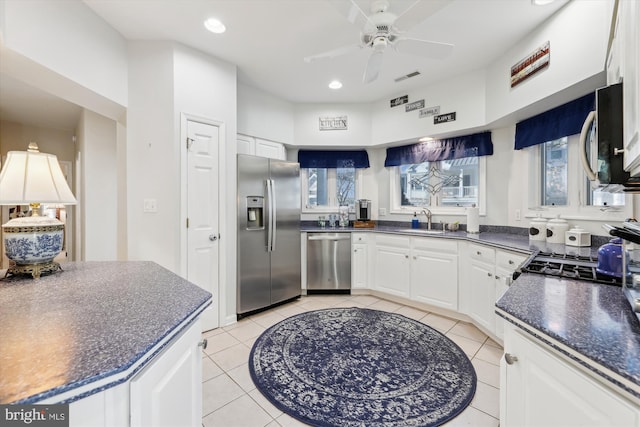 kitchen with sink, white cabinets, light tile patterned flooring, and appliances with stainless steel finishes