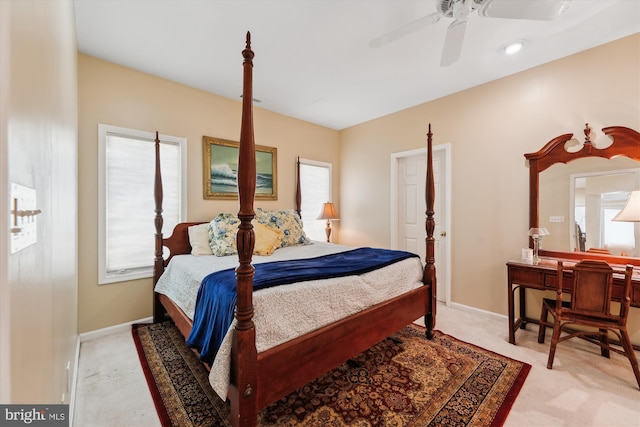 bedroom with light colored carpet, ceiling fan, and multiple windows