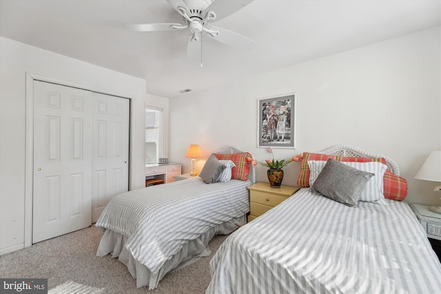 carpeted bedroom with ceiling fan and a closet