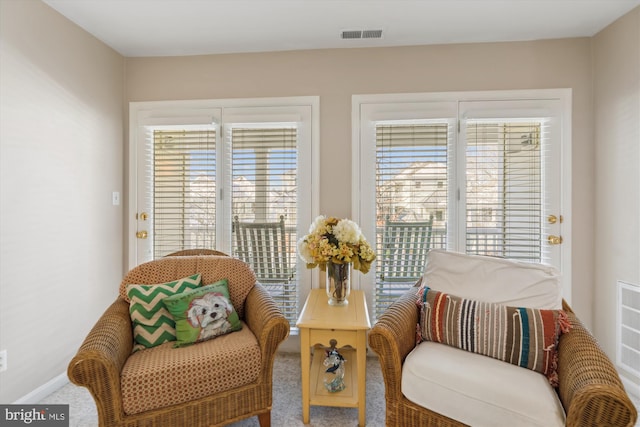 sitting room with carpet floors and a healthy amount of sunlight