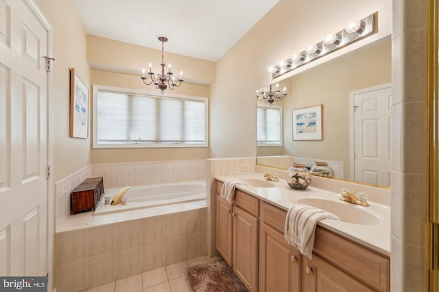 bathroom featuring a notable chandelier, tile patterned flooring, vanity, and a relaxing tiled tub