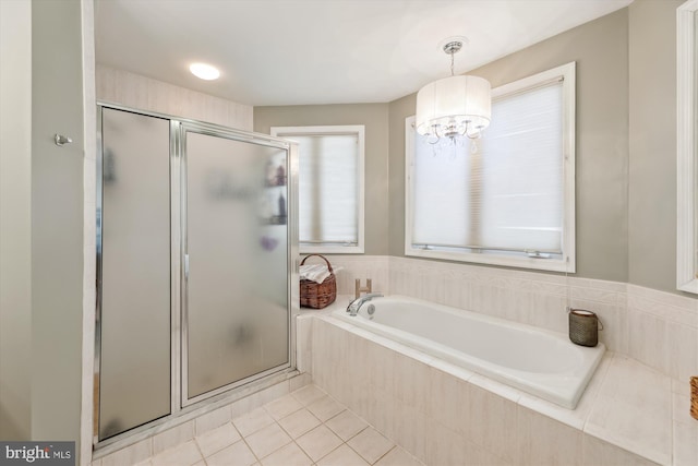 bathroom with tile patterned flooring, a chandelier, and independent shower and bath