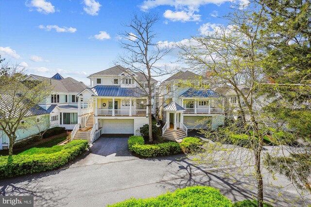 39281 Piney Dr Unit 55115, Bethany Beach, DE 19930 - view of front of home featuring a standing seam roof, metal roof, aphalt driveway, an attached garage, and stairs