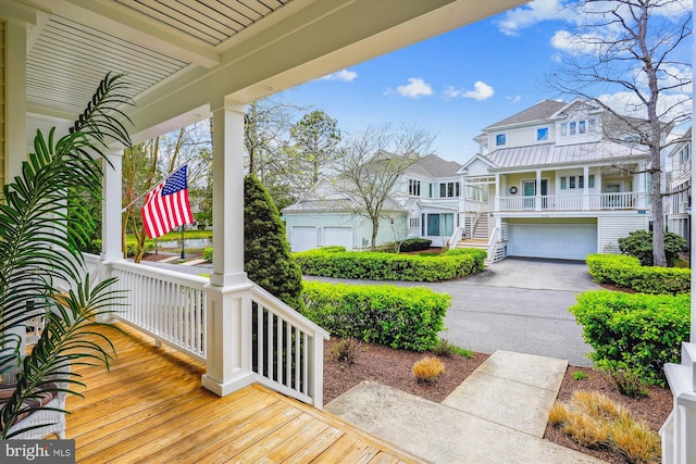 39281 Piney Dr Unit 55115, Bethany Beach, DE 19930 - exterior space with a residential view, an attached garage, aphalt driveway, a porch, and stairway