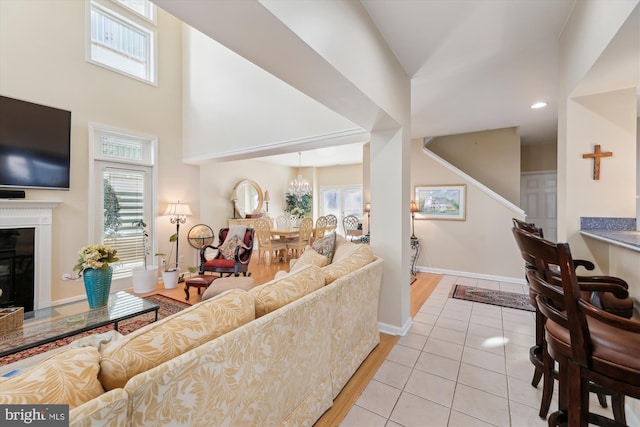 living room with a notable chandelier, a high ceiling, and light tile patterned floors