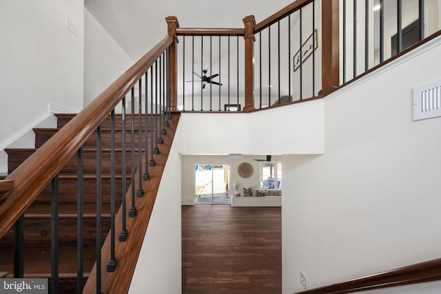 stairs with a towering ceiling and hardwood / wood-style flooring