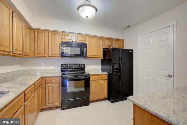 kitchen with light stone countertops and black appliances