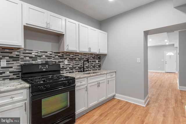 kitchen with white cabinetry, sink, black range with gas cooktop, and light stone counters