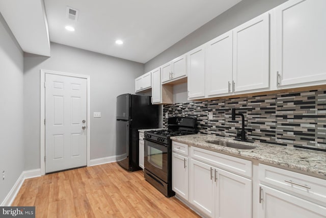 kitchen featuring decorative backsplash, sink, white cabinets, and black appliances