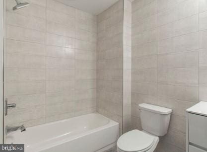 full bathroom with toilet, vanity, bathing tub / shower combination, and tile walls