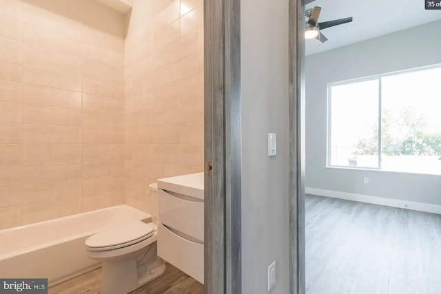 full bathroom with hardwood / wood-style floors, vanity, tiled shower / bath, ceiling fan, and toilet