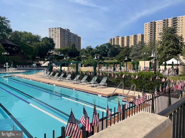 pool featuring a city view, fence, and a patio