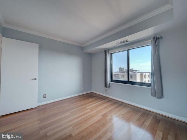 unfurnished room featuring baseboards, ornamental molding, visible vents, and light wood-style floors