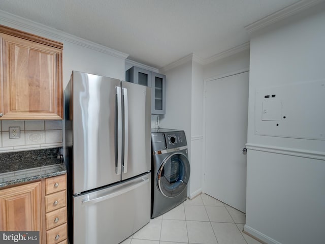 kitchen featuring light tile patterned floors, washer / clothes dryer, glass insert cabinets, freestanding refrigerator, and dark stone counters