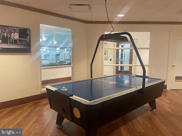 game room featuring a paneled ceiling, visible vents, baseboards, and wood finished floors