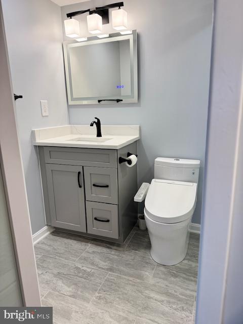 half bath featuring toilet and vanity