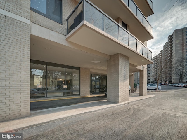 view of exterior entry featuring a view of city and brick siding