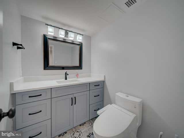 half bathroom featuring toilet, visible vents, and vanity