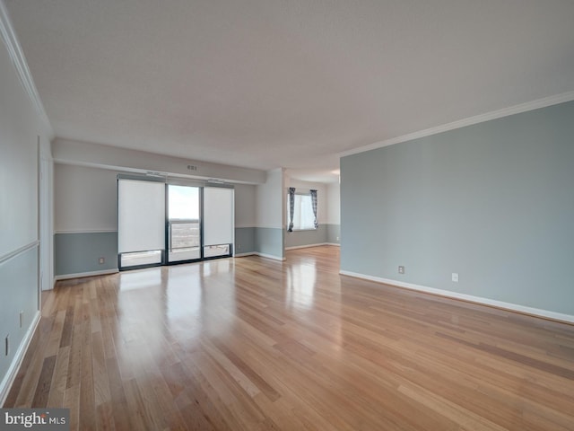 unfurnished living room with light wood-style flooring, ornamental molding, and baseboards