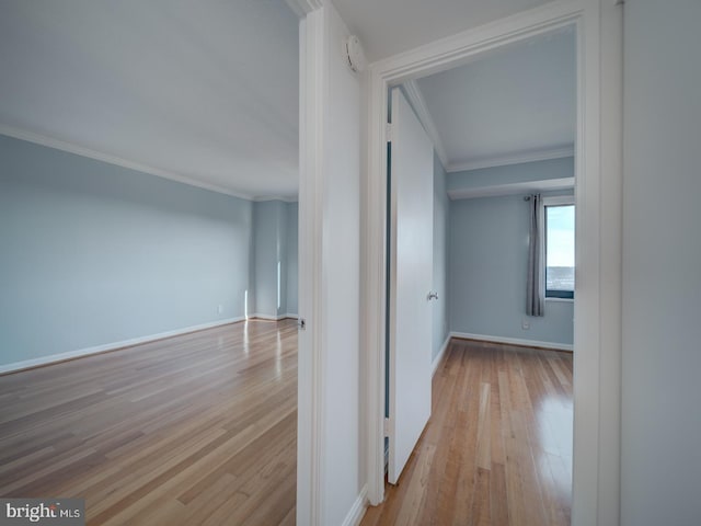 hall with baseboards, light wood-type flooring, and crown molding