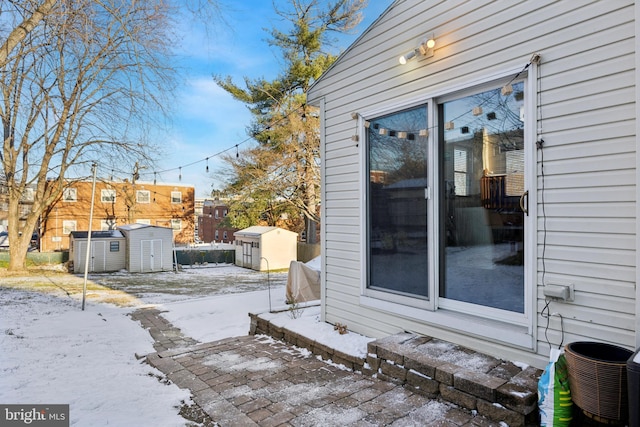 view of snow covered exterior featuring central AC and a shed