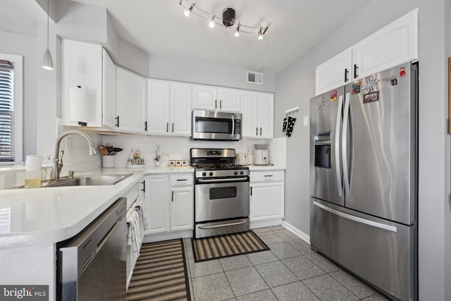 kitchen featuring sink, stainless steel appliances, backsplash, pendant lighting, and white cabinets