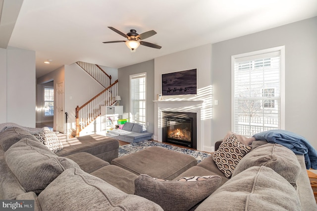 living room with a fireplace, ceiling fan, and a healthy amount of sunlight