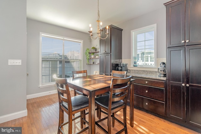 dining area featuring light hardwood / wood-style floors and a notable chandelier