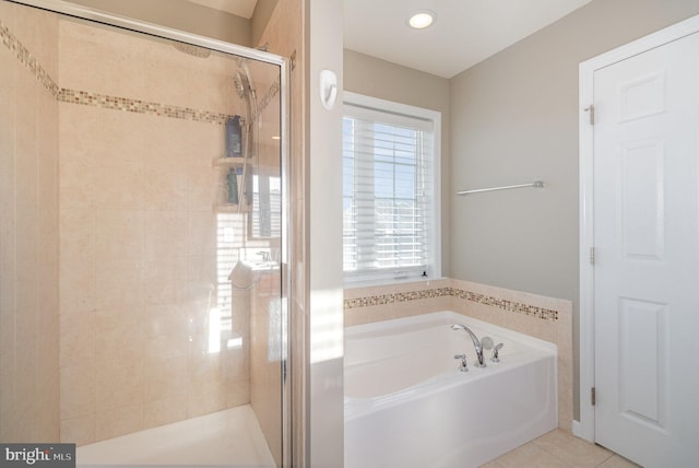 bathroom with tile patterned floors and shower with separate bathtub