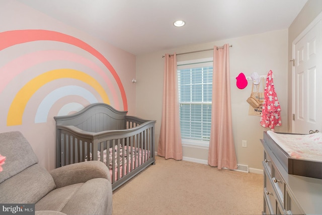 carpeted bedroom with a nursery area